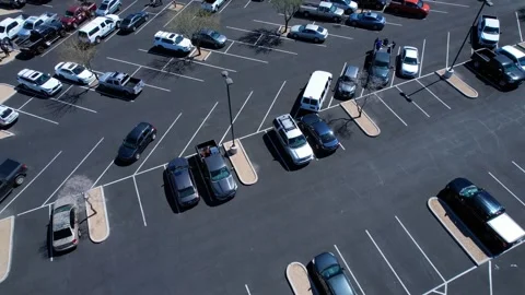 Downward aerial view of vehicles in a large parking lot Stock Footage 172067577