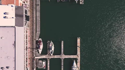Downward angle drone shot of boats in a small harbor. Stock Footage 305760192