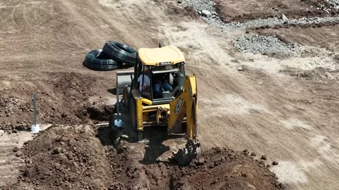 Downward angle shot capturing a yellow heavy-duty loader tractor working on a Stock Footage 337479249