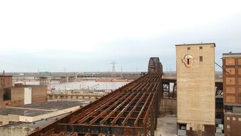 Downward crane shot past elevated train tracks in industrial area Stock Footage 104876119