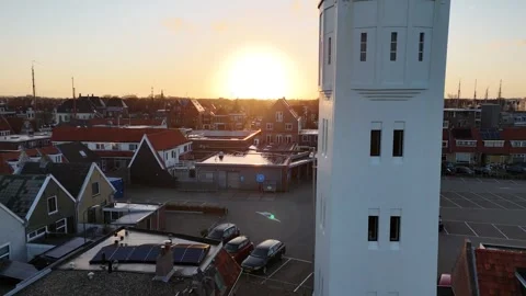 Downward move beside lighthouse toward entrance at sunrise Stock Footage 331841922