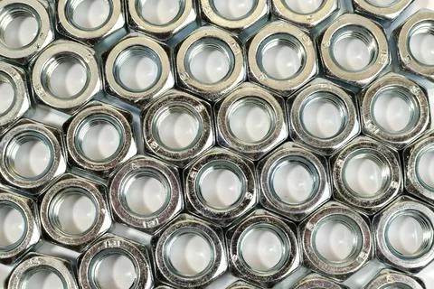 Dozens of silver nuts lined up in rows - stock photo Stock-Fotos