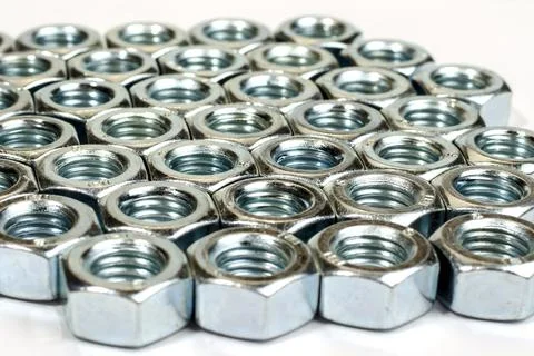 Dozens of silver nuts lined up in rows - stock photo Stock Photos