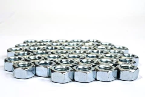 Dozens of silver nuts lined up in rows - stock photo Stock Photos