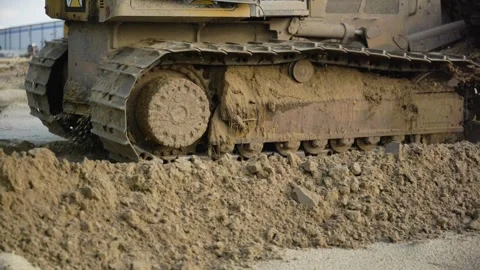 Dozer backing up with sand flying off tracks | slo-mo Stock Footage 249762452