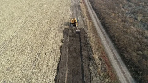 Dozer with bucket, preparing for macadam service road in a crop field. Stock Footage 101388824