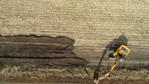 Dozer with bucket, preparing for macadam service road in a crop field. Stock-Footage 101389200