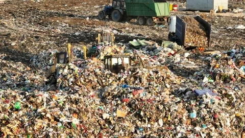 Dozer on landfill. Garbage dump with waste plastic Stockbeeldmateriaal 218428454