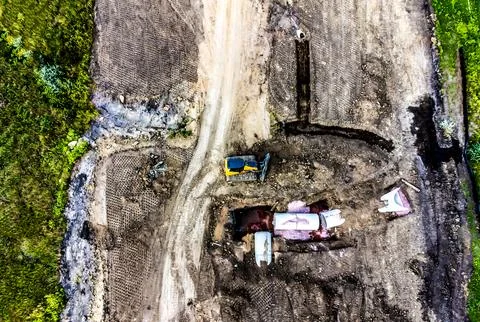 Dozer next to an open trench with two culverts ready for a connection juncture. Stock Photos