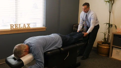 Dr adjusting patients lower back Stock Footage 107767519