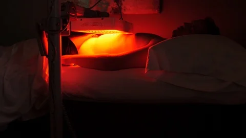 Dr assists man under red light therapy Stock-Footage 107767137