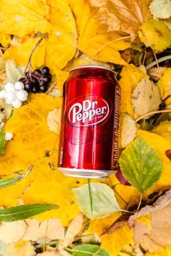 Dr Pepper a glass tin bottle on autumn yellow green foliage of trees Stock Photos
