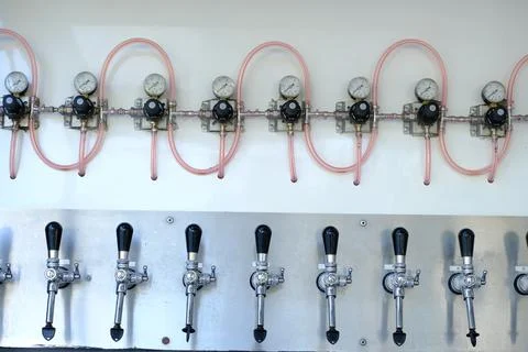 Draft beer tapping system. Pressure gauges, taps and pipes in a bar serving d Stock Photos