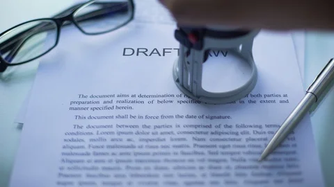 Draft law approved, officials hand stamping seal on business document, close up Stockbeeldmateriaal 100692084