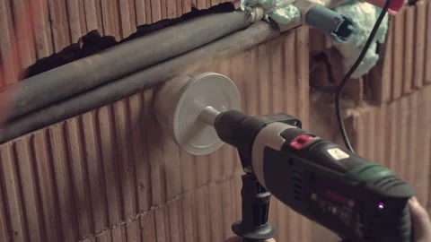 Draft plumbing installation. Drilling hole in wall for socket or blumbing tubes Stock Footage 234453063