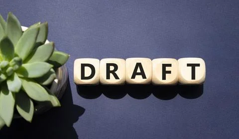 Draft symbol. Concept word Draft on wooden cubes. Beautiful deep blue backg.. Foto stock