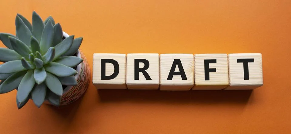 Draft symbol. Concept word Draft on wooden cubes. Beautiful orange backgrou.. Stock Photos