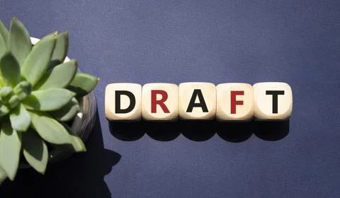 Draft symbol. Concept word Draft on wooden cubes. Beautiful deep blue backg.. Stock Photos