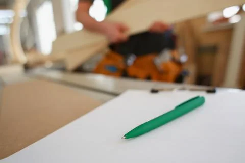 Drafting green pen lying on desk on clipboard Stock Photos