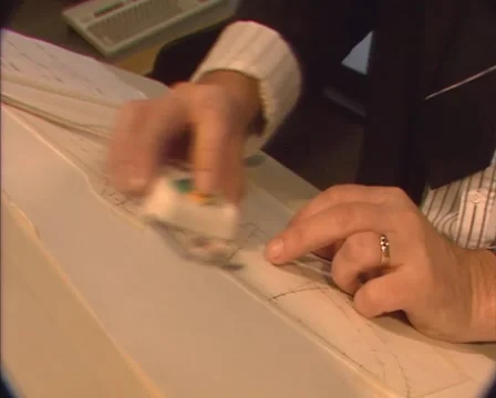 Draftsman modifying a paper drawing, using a ruler and computer mouse, 1980s Stock Footage 46784146