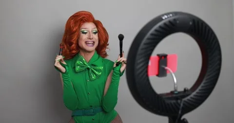 Drag queen influencer doing social media live teaching makeup to her followers Stock Footage 155437883