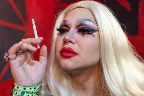 Drag queen posing with cigarette in a hand. A wig with white long hair Stock Photos