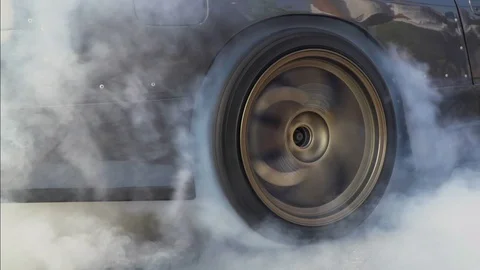 Drag racing car burns rubber off its tires in preparation for the race Vídeos de archivo 73965586