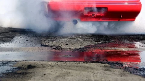 Drag racing car burns rubber off its tires in preparation for the race Stock Footage 85713587