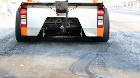 Drag racing car burns rubber off its tires in preparation for the race Stock Footage 85713657