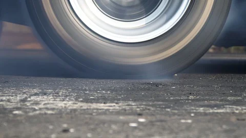 Drag racing car burns rubber off its tires in preparation for the race Stock Footage