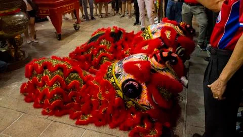 Dragon dance performance between crowded people inside the temple. Stock Photos