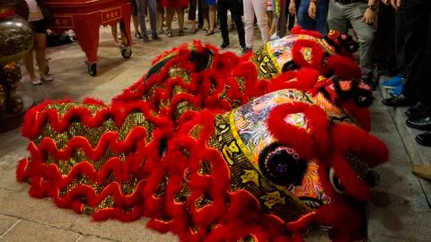 Dragon dance performance between crowded people inside the temple. Stock Photos