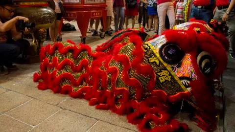 Dragon dance performance between crowded people inside the temple. Stock Photos