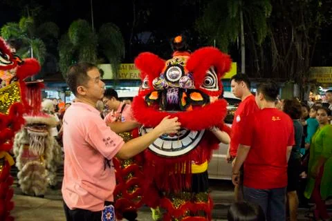 Dragon dance performance between crowded people inside the temple. Stock Photos