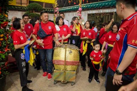 Dragon dance performance between crowded people inside the temple. Stock Photos