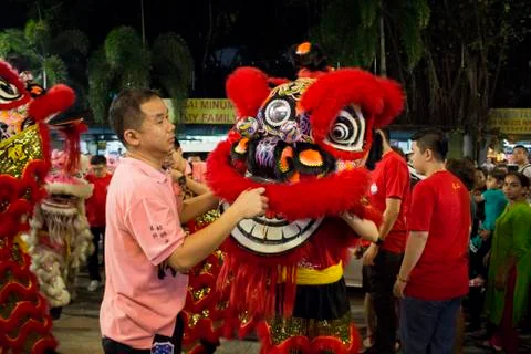 Dragon dance performance between crowded people inside the temple. Stock Photos