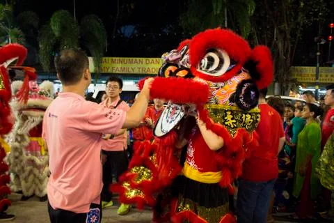 Dragon dance performance between crowded people inside the temple. Stock Photos
