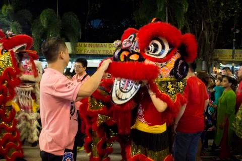 Dragon dance performance between crowded people inside the temple. Stock Photos