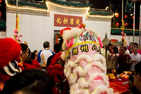 Dragon dance performance between crowded people inside the temple. Stock Photos