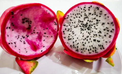 Dragon Fruit Cut in Half, half already eaten, the other whole Stock Photos