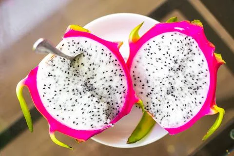 Dragon fruit cut into halves on the table, top view. Delicious healthy juicy  Stock Photos