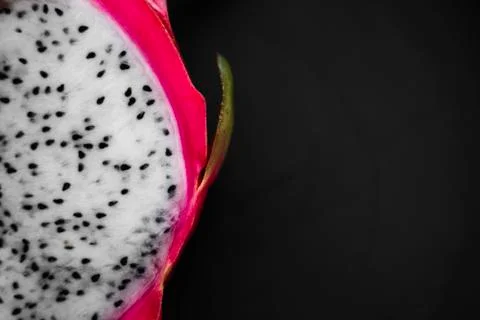 Dragon fruit. Vibrant Dragon Fruit on black background. Sliced white dragon Stock Photos