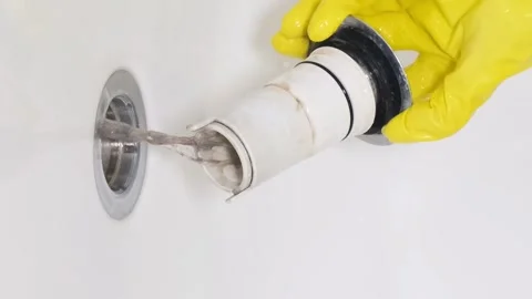 The drain in the bathtub is completely clogged with human hair. Vertical video Stock Footage 250028565
