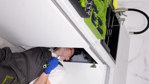 Drain cleaning will be done by a professional plumber dressed in a uniform. The Stock Footage 250027763