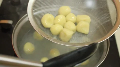 Drain cooked, boiled food. Round shaped food Stock Footage 334647366