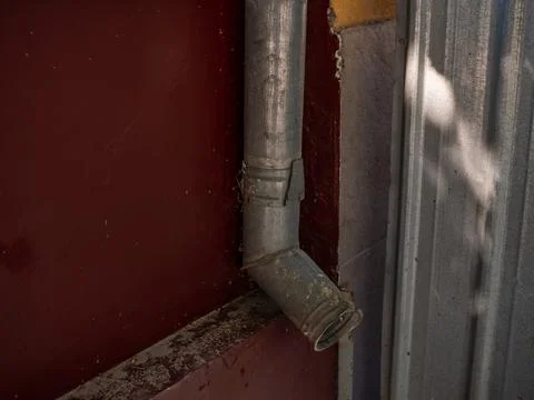 Drain pipe on the brown brick wall. Downspout. Stock Photos