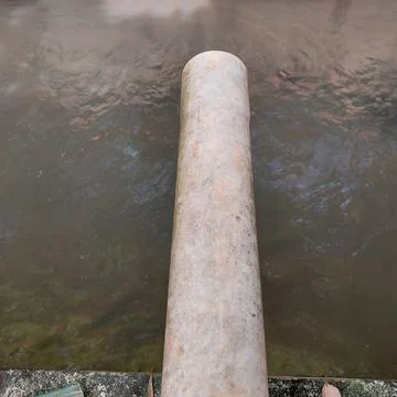 Drain pipe to the river Stock Photos