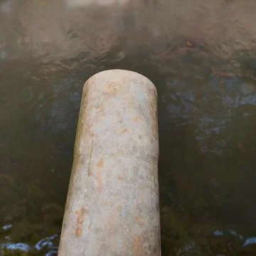 Drain pipe to the river Stock Photos