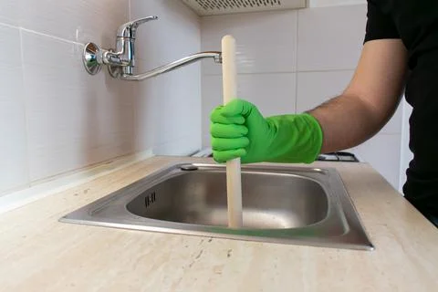 Drain Problems, blockage plumbing kitchen sink unclog plunger man hand hold Foto stock
