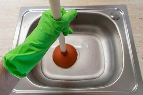 Drain Problems, blockage plumbing kitchen sink unclog plunger man hand hold Foto stock